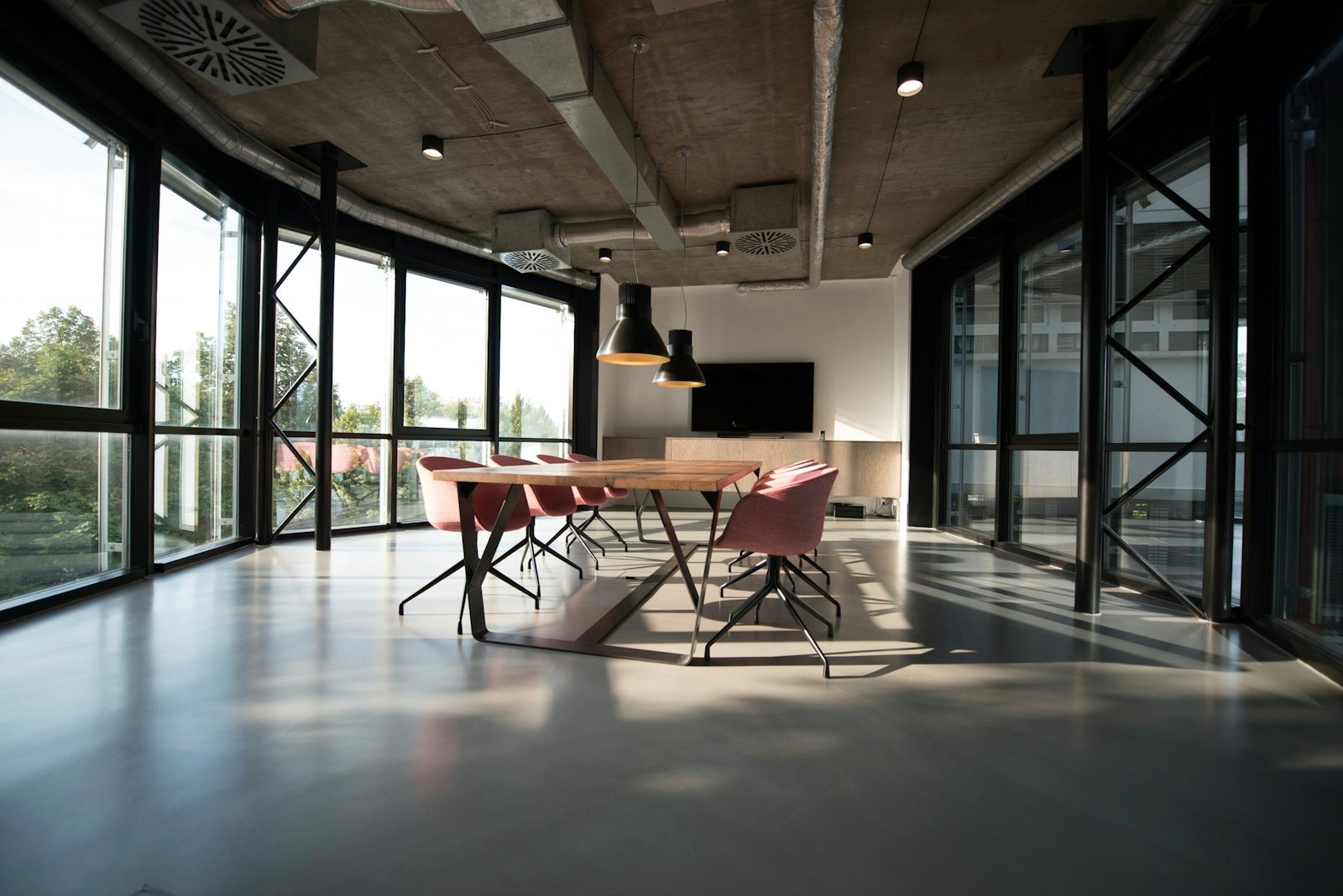 A bright conference room with floor-to-ceiling windows and a clean polished floor